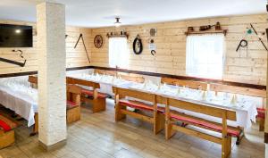a dining room with white tables and chairs at Penzión u Komu Žaškov, okres Dolný Kubín in Žaškov