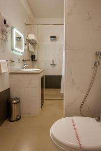 a white bathroom with a toilet and a sink at Norbu Healing Hotel in Thimphu +14 photos