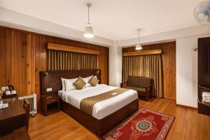 a hotel room with a bed and a desk at Norbu Healing Hotel in Thimphu