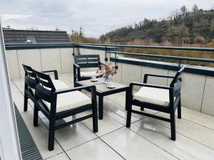 a balcony with three chairs and a table on a roof at LOFT - Exclusive Penthousewohnung in Könen
