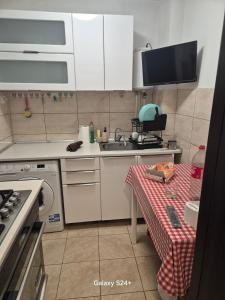 a kitchen with white cabinets and a table and a sink at ARTIFICII București in Bucharest +12 photos