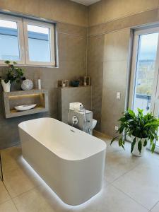 a large white bath tub in a bathroom at LOFT - Exclusive Penthousewohnung in Könen +19 photos