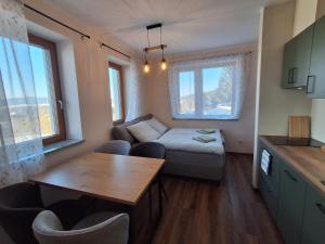 a small living room with a table and a couch at Apartmány pod Štěpánkou in Kořenov