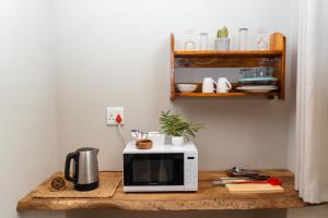 a microwave sitting on a wooden table with a coffee maker at Shumba Safari Bush Camp in Hoedspruit