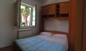 1 dormitorio con 2 camas y ventana en Apartments Lili, en Ankaran
