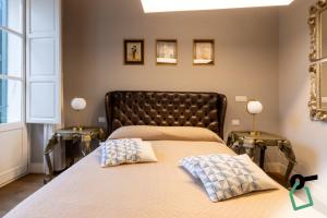 a bedroom with a bed with two side tables at Hotiday Cagliari Porto in Cagliari