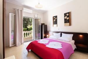 a bedroom with a large bed with a red blanket at The Olive Grove Cottage by Konnect - 2,5km from Ipsos in Ipsos
