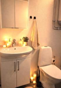 a bathroom with a sink and a toilet and candles at Frost Longstay Lakeside in Kiruna