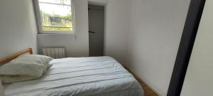 a bed in a small room with a window at Sous les toits de Béthune in Béthune