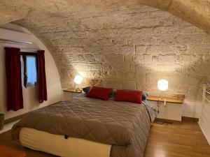 a bedroom with a bed in a stone wall at Casa Mola di Bari in Mola di Bari