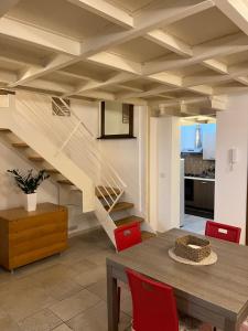 a dining room with a wooden table and a staircase at Casa Mola di Bari in Mola di Bari