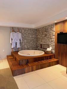 ein großes Badezimmer mit Badewanne und Fernseher in der Unterkunft Villa Sol e Mar in Maragogi + 37 Fotos