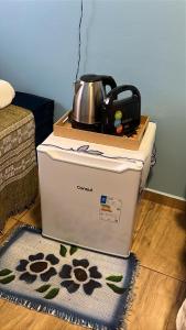 a tea kettle sitting on top of a refrigerator at Pousada Nunes in Lauro Müller