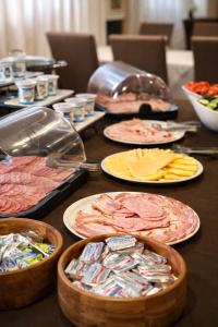 a table with many plates of food on it at Hotel Trio Giroc in Giroc
