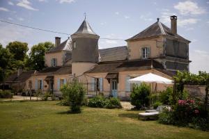 an old house with a grass yard in front of it at Château La Barge - Dordogne in La Boissière-dʼAns