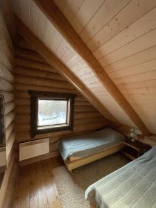 a bedroom in a log cabin with two beds at Nordic Log-House with Sauna in Valga