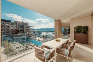 a balcony with a table and chairs and a view of the city at Regent Porto Montenegro in Tivat