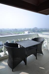 a black table and chairs on a balcony at Namaste Corbett Resort and Spa in Jāmb