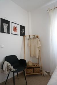 a bedroom with a chair and a white wall at Villa Tsakalaki in Stavríon