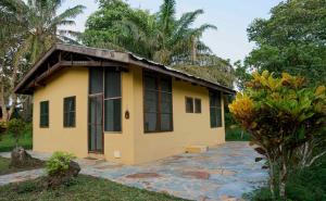 a small yellow house with a roof at Ankobra Beach Resort in Axim
