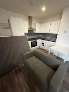 a kitchen with a couch in the middle of a kitchen at Kensway House in Ilford