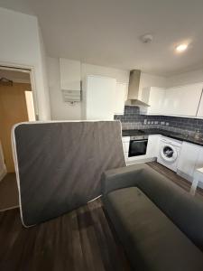 a kitchen with white cabinets and a stove top oven at Kensway House in Ilford