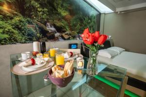 a glass table with a vase of red flowers on it at Motel Scala in Salvador