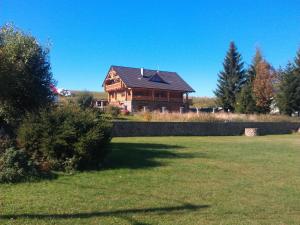 a large wooden house in the middle of a field at Kolnicka Krahule in Krahule