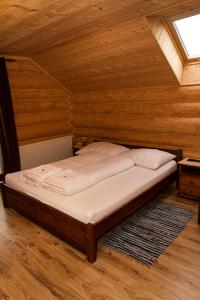 a bed in a room with a wooden ceiling at Kolnicka Krahule in Krahule