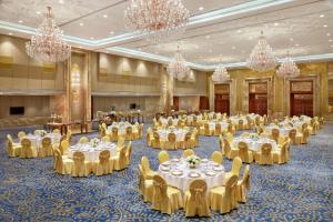 a banquet hall with white tables and chairs and chandeliers at The Reverie Saigon - The Leading Hotels of the World in Ho Chi Minh City +117 photos