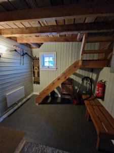 an attic room with a staircase and a bench at The Old Cottage in Harstad