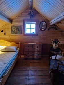 a bedroom with a bed and a window in a cabin at The Old Cottage in Harstad