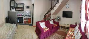 a living room with two chairs and a tv at Eve's Place Transient Apartment in Tanay