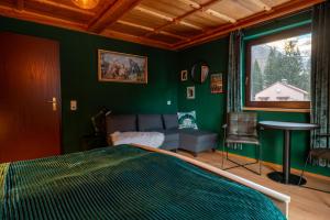 a green bedroom with a bed and a couch at Haus Waldruhe in Mallnitz