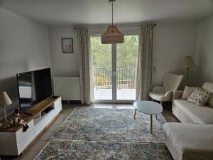 a living room with a couch and a tv at Appartement Belle Vue in Gréoux-les-Bains