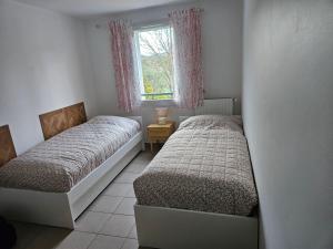 two beds in a small room with a window at Appartement Belle Vue in Gréoux-les-Bains