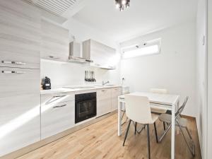 a kitchen with white cabinets and a table and chairs at Gentilè in Bari