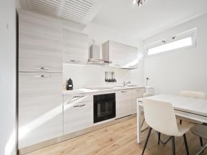 a kitchen with white cabinets and a table and chairs at Gentilè in Bari