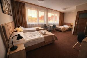 a hotel room with two beds and a table at Załęże in Katowice