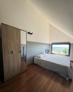a bedroom with a bed and a large window at Villa Naiya in Saint-Paul