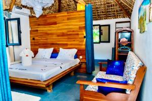 a bedroom with a bed and a chair in a room at VILLA AMNESYA NOSY BE in Nosy Be +68 photos
