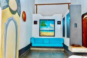 a blue couch in a room with a painting on the wall at VILLA AMNESYA NOSY BE in Nosy Be