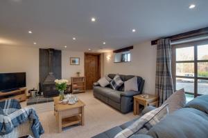 a living room with a couch and a tv at 3 Bed in South Molton oc-millba in Bishops Nympton