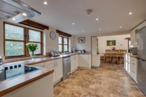 a large kitchen with white cabinets and a dining room at 3 Bed in South Molton oc-millba in Bishops Nympton