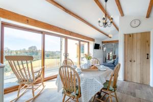 a dining room with a table and chairs and a large window at 3 Bed in Bish Mill oc-e30946 in Bishops Nympton