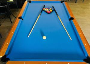 a pool table with two cue sticks and a ball at צימר פלטינום - צימר עם ג'קוזי פרטי בערד in Arad
