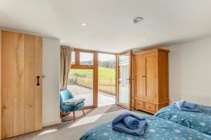 a bedroom with two beds and a sliding glass door at 3 Bed in Bish Mill oc-e30946 in Bishops Nympton