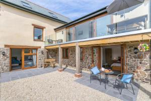 a patio of a home with a table and chairs at 3 Bed in Bish Mill oc-e30946 in Bishops Nympton