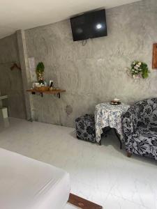 a bedroom with a bed and a table and a couch at Phumaihom Resort in Hat Yai