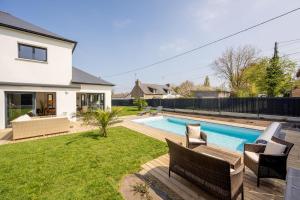 a backyard with a swimming pool and a house at Le Clos Carnonen, villa avec piscine in Quessoy